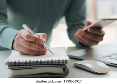 Businessmen use mobile phones and take notes on their notebooks while working on laptop computers, online business,work from home, teleworking concept.