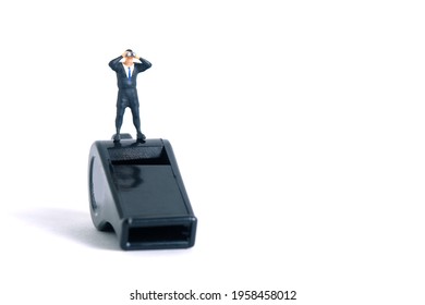 Businessmen using binoculars standing above black whistle. Miniature tiny people toys photography. isolated on white background.