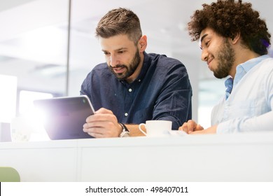 Businessmen Using Tablet Computer In Office