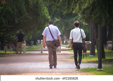 businessmen walking at park, they wearing an elegant white shirt and working bag