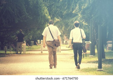 businessmen walking vintage effect, two persons on foot at the park