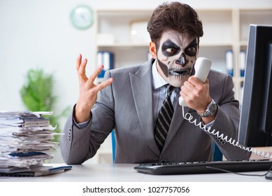 Businessmsn With Scary Face Mask Working In Office