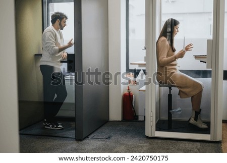 Businesspeople analyzing, discussing solutions and making decisions during a video meeting in a phone booth.