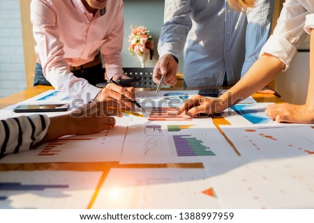 Businesspeople analyzing investment graph meeting brainstorming and discussing plan in meeting room, investment concept