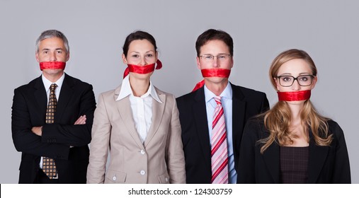 Businesspeople bound by red tape around their mouths standing in a row unable to speak or divulge information - Powered by Shutterstock