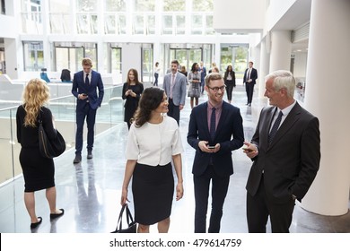 Businesspeople In Busy Lobby Area Of Modern Office