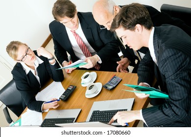 Businesspeople Crunching The Numbers Of A Business Plan