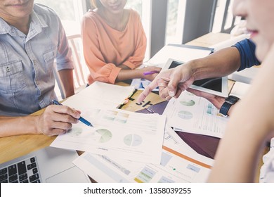 Geschäftsleute diskutieren ein Projekt. Eine Frau am Computer zeigt den Partnern Infografiken an. Ein Beispiel für gute Beziehungen bei der Arbeit.