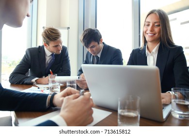 Businesspeople discussing together in conference room during meeting at office.