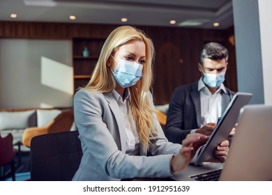 Businesspeople With Face Masks Sitting In A Cafe And Having Business Meeting. Woman Using A Tablet. Zoom Meeting, Technology, Telecommunications During COVID-19, Coronavirus