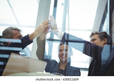 Businesspeople Giving A High Five To Each Other In Office