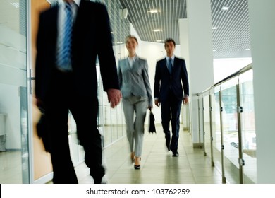 Businesspeople Going Along Corridor Inside Office Building