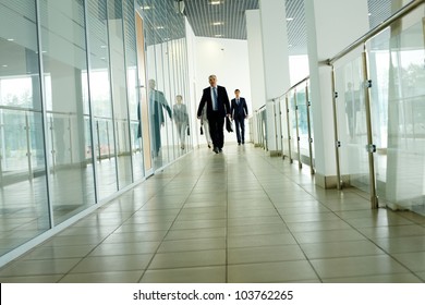 Businesspeople Going Along Corridor Inside Office Building