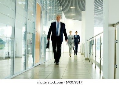 Businesspeople Going Along Corridor Inside Office Building