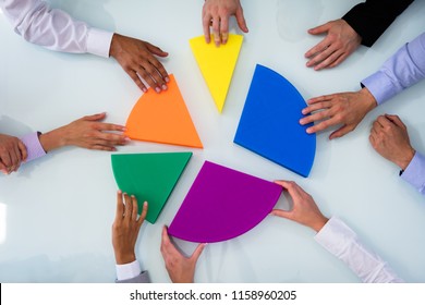 Businesspeople Hand Connecting Multi Colored Pieces Of Pie Chart On Desk - Shutterstock ID 1158960205
