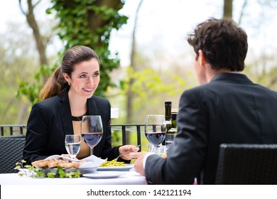 Businesspeople having business lunch outside on the terrace in a fine dining restaurant
