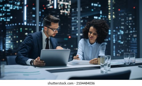 Businesspeople in Modern Office: Business Meeting of Two Managers. CEO and Operations Director Talk, Discuss, Brainstorm Corporate Strategy, Implementing Marketing and Financial Plans. Evening.