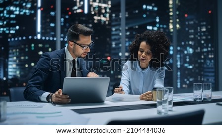 Businesspeople in Modern Office: Business Meeting of Two Managers. CEO and Operations Director Talk, Discuss, Brainstorm Corporate Strategy, Implementing Marketing and Financial Plans. Evening.