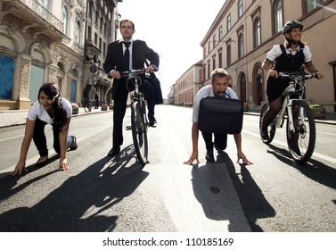 Businesspeople riding on bikes and running in city