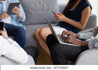 Geschäftsleute, die mit Laptop, Smartphone, Tablet-PCs auf dem Sofa sitzen, arbeiten online, während Menschen aus der Gadget-Ära ihre Geräte benutzen, um Informationen zu sammeln, ständig interagieren, aktive Nutzung des Cyberspace-Konzepts