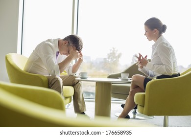 Businesspeople In Serious Discussion At Office Lobby