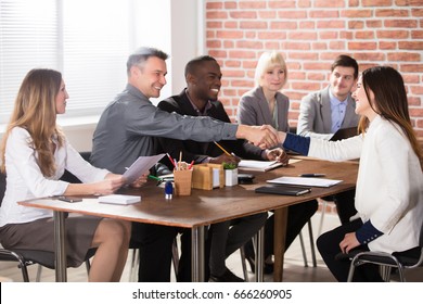Businesspeople Shaking Hands After Finishing Up A Meeting In Office