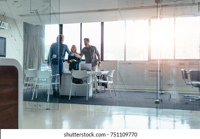 Businesspeople shaking hands after meeting in board room. Businessman shaking hands with female in conference room at office.