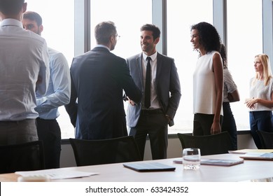 Businesspeople Shaking Hands Before Meeting In Boardroom - Powered by Shutterstock