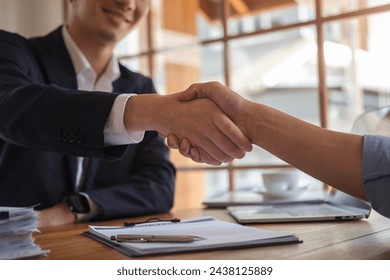 Businesspeople shaking hands in office. - Powered by Shutterstock