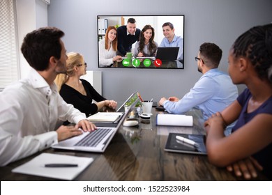 Businesspeople Sitting In A Conference Room Looking At Computer Screen