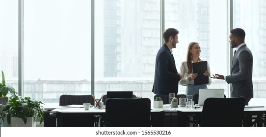 Businesspeople Talking In Office, Standing Against Window By Table, Panorama, Copy Space