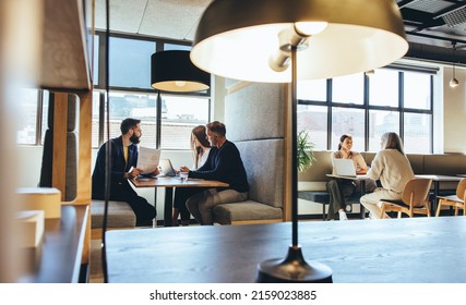 Businesspeople working in a modern co-working space. Diverse business professionals having discussions while sitting in an open workspace. Entrepreneurs collaborating on new projects. - Shutterstock ID 2159023885