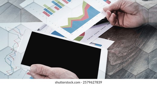 Businessperson analyzing financial charts with tablet computer, geometric pattern