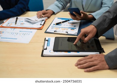 A businessperson  financial analyst during a corporate meeting. review a graph document, discussing financial data and strategies to ensure successful outcomes effective teamwork achieving corporate - Powered by Shutterstock