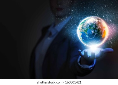Businessperson holding planet Earth in palm. Elements of this image are furnished by NASA