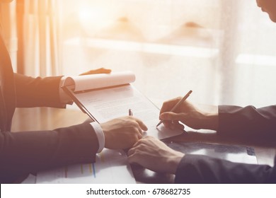 Businessperson Signing Contract about insurance, Two men writing with pen sign of modest agreements form In modern office, morning light, vintage color, success of business partners concept - Shutterstock ID 678682735