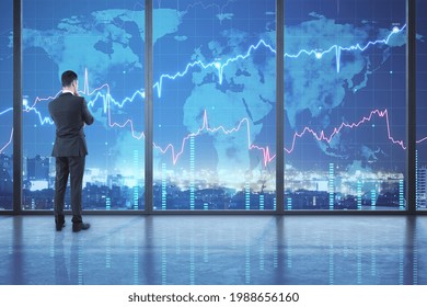 Businessperson standing in modern office interior with forex chart and night city view. Occupation and trade concept