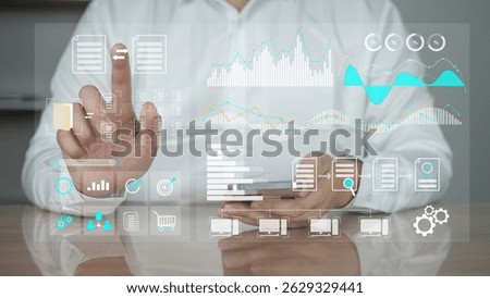 A businessperson using a transparent virtual interface with interactive analytics, graphs, and control icons. Represents concepts of business intelligence, data analytics, digital transformation.