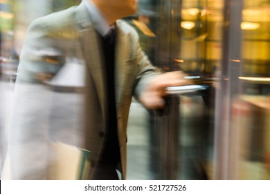 Businessperson Walking Through The Revolving Door In Motion Blur