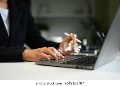 Businessperson working on laptop with digital interface icons, symbolizing data analytics, and global connectivity
