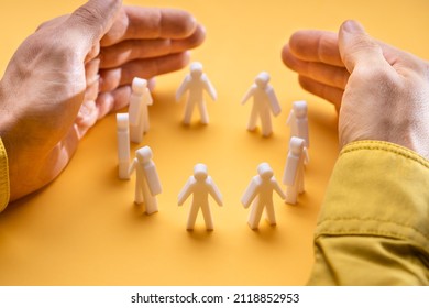 Businessperson's Hand Protecting Person Figures On Yellow Background - Shutterstock ID 2118852953