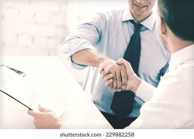 businesss and office concept - two businessmen shaking hands in office - Shutterstock ID 229882258