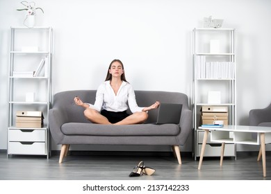 Businesswoman Accountant In Formal Wear Doing Yoga Exercise On Sofa At Workplace In Office. Employee Feel Balance Harmony Relaxation. Calm Accountant Girl In Office.