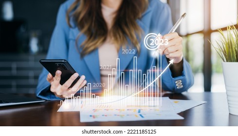 Businesswoman analyzes profitability of working company with digital virtual screen graphics. 2023 Planning invest indicators long-term. positive of businessman calculates financial data investments. - Shutterstock ID 2221185125
