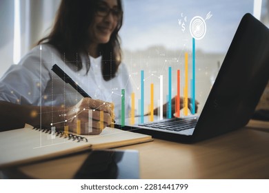 Businesswoman analyzing company's financial balance sheet working with digital augmented reality graphics. Businesswoman calculates financial data for long-term investment. - Powered by Shutterstock