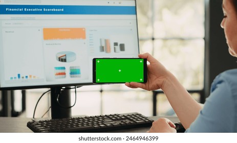 Businesswoman analyzing smartphone app with greenscreen template in startup coworking space. Person looking at isolated chromakey display with mockup on digital mobile device, copyspace. - Powered by Shutterstock