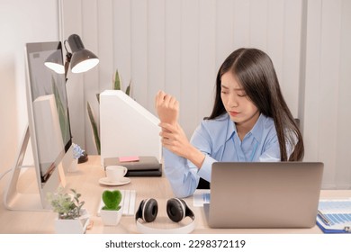 Businesswoman asia is sitting at workplace and feeling muscle aches from hard work. Office syndrome concept. - Powered by Shutterstock