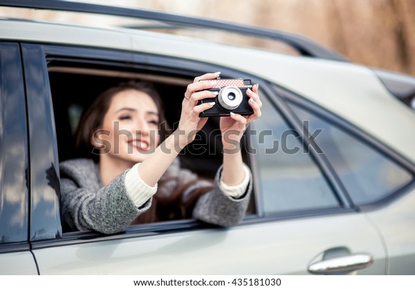 Businesswoman, bank and insurance worker. Tourist\
people concept - beautiful successful woman make photo on camera\
outside the car.