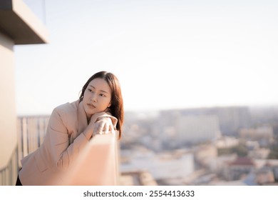 Businesswoman in a beige blazer leans on a balcony railing, contemplating the cityscape in the soft morning light, her thoughtful expression suggesting deep reflection - Powered by Shutterstock