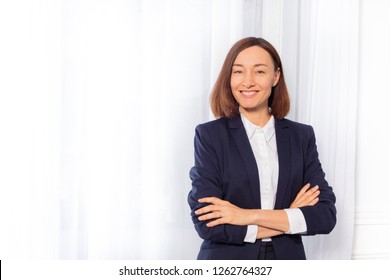 Businesswoman In Blue Suit Jacket With Arms Folded